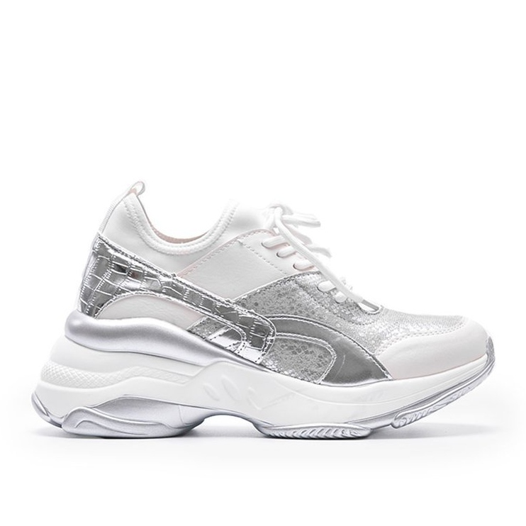 Vita och silver sneakers på en tjock Lea -sula