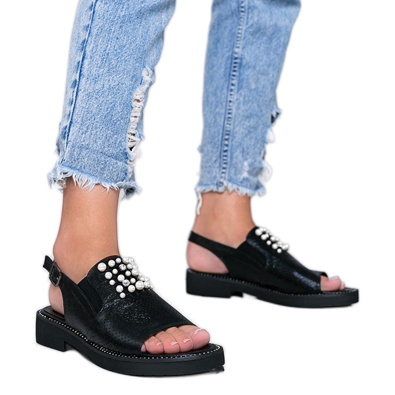 Svarta sandaler med pärlor som en kvinna