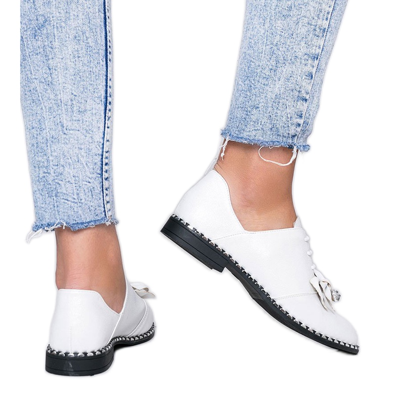 Vita blanka skor med en Lost Stars -rosett