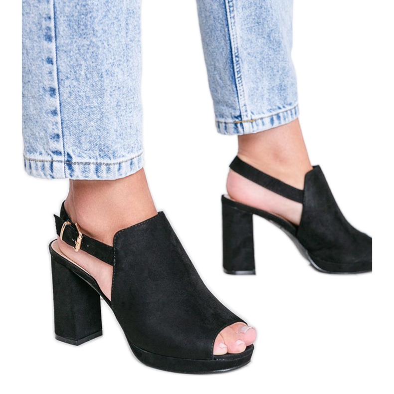 Svarta sandaler på en hallickstolpe