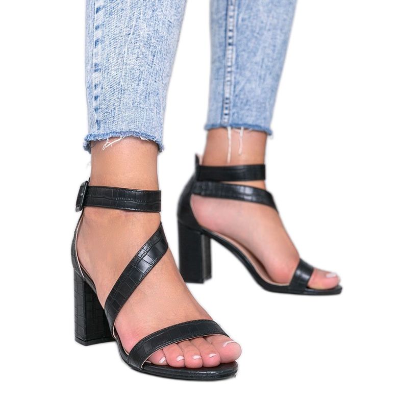 Svarta sandaler på en Silver Dust stolpe