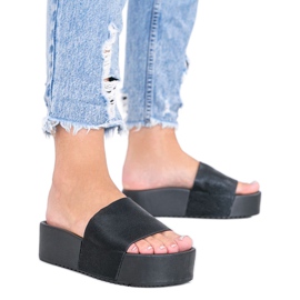 Svarta tofflor på en tjock Crysta -sula