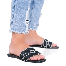 Svarta tofflor med en dekorativ Stormi -övre