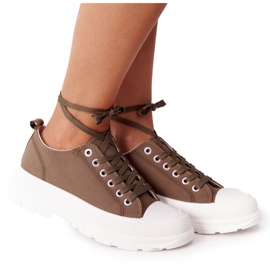 Kvinnors sneakers på den gröna restidplattformen