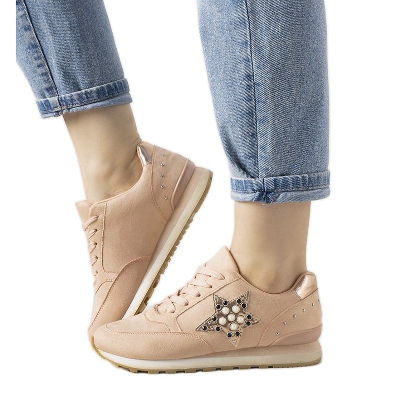 Rosa sportskor som är dekorerade med linjal dubbar