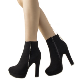 Svarta eleganta stövlar på Torment -stolpen