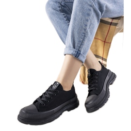 Svarta sneakers på en tjock Beat -sula