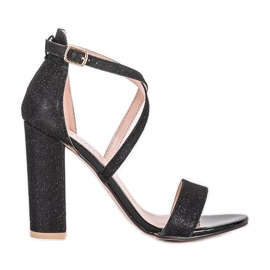 Svarta sandaler på en Silver Dust stolpe