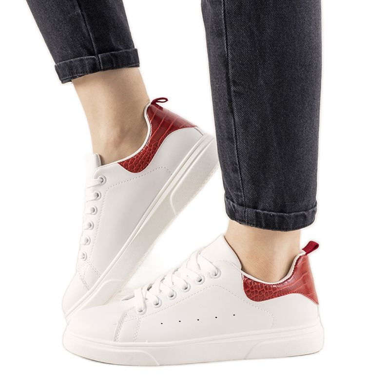 Röda och vita sneakers på en tjock Influ -sula