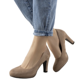 Beige pumpar på en Sara ekoläderspelare