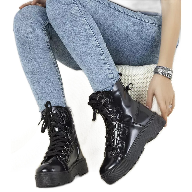 Svarta stövlar på en hög Orane sula