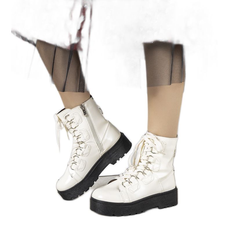 Vita stövlar på en hög Orane sula ecru