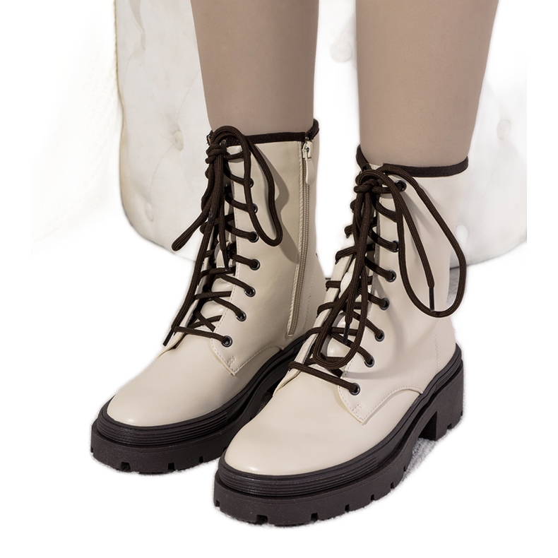 Beige isolerade stövlar på en tjock Dena-sula