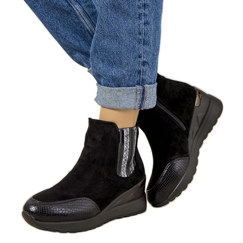 Svarta stövlar på en isolerad wedge Trento