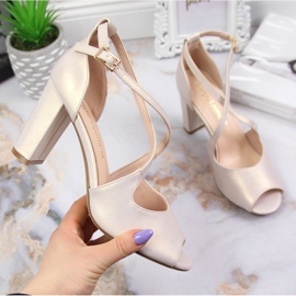 Damsandaler på en pärlemorfärgad beige Sergio Leone stolpe