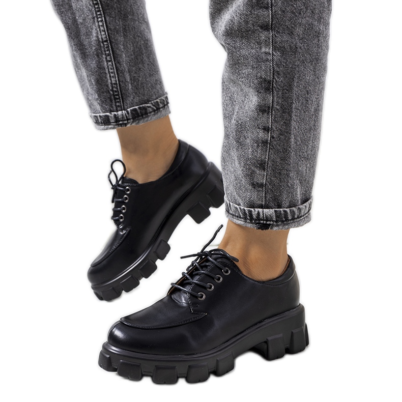 Svarta skor på en Feline traktorsula