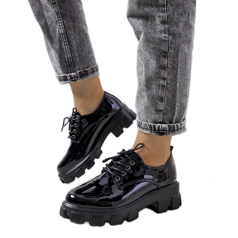 Svartlackade skor på traktorsula Wind