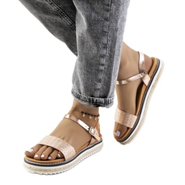 Gyllene sandaler på en utsmyckad Acton-plattform