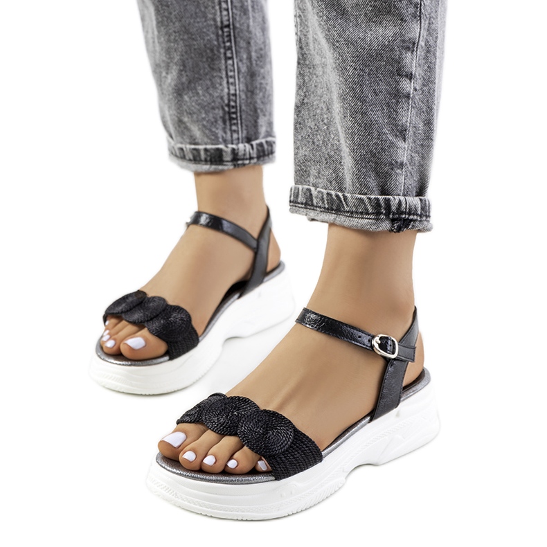 Svarta sandaler på Nandy-plattformen