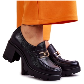 Läderskor på en pelare med en gyllene ornament svart Mikeyla