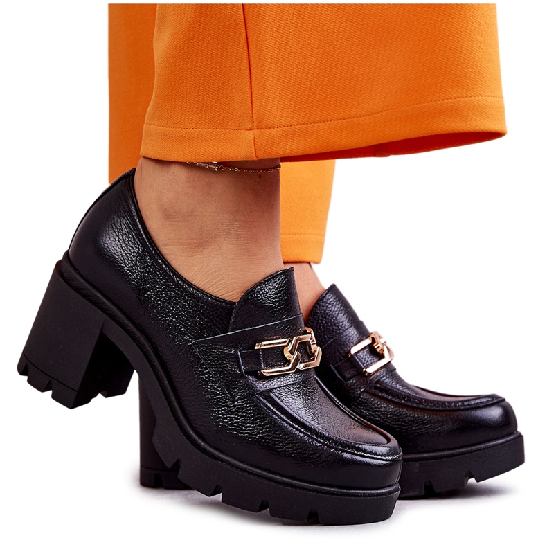 Läderskor på en pelare med en gyllene ornament svart Mikeyla