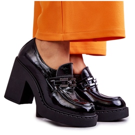 Lackade skor på en massiv svart Jaime-stolpe