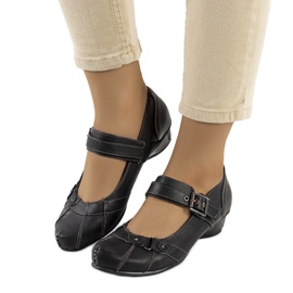 Svarta pumps fästa med ett Gomez-bälte