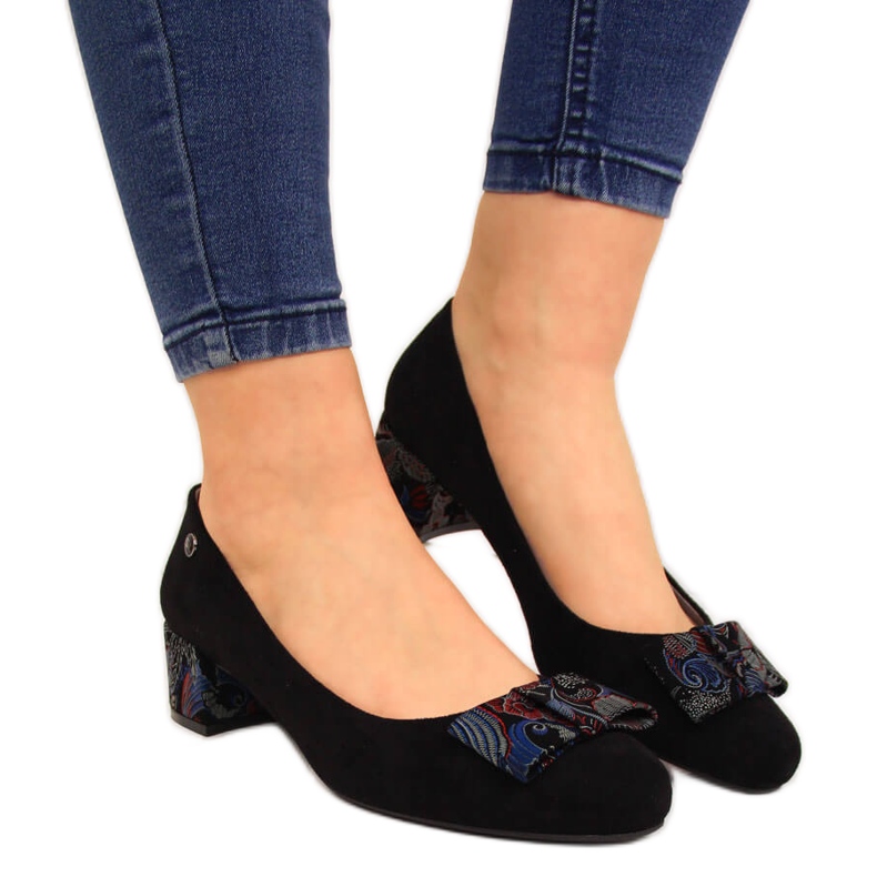 Svarta pumps på en dekorativ rosett från Sergio Leone