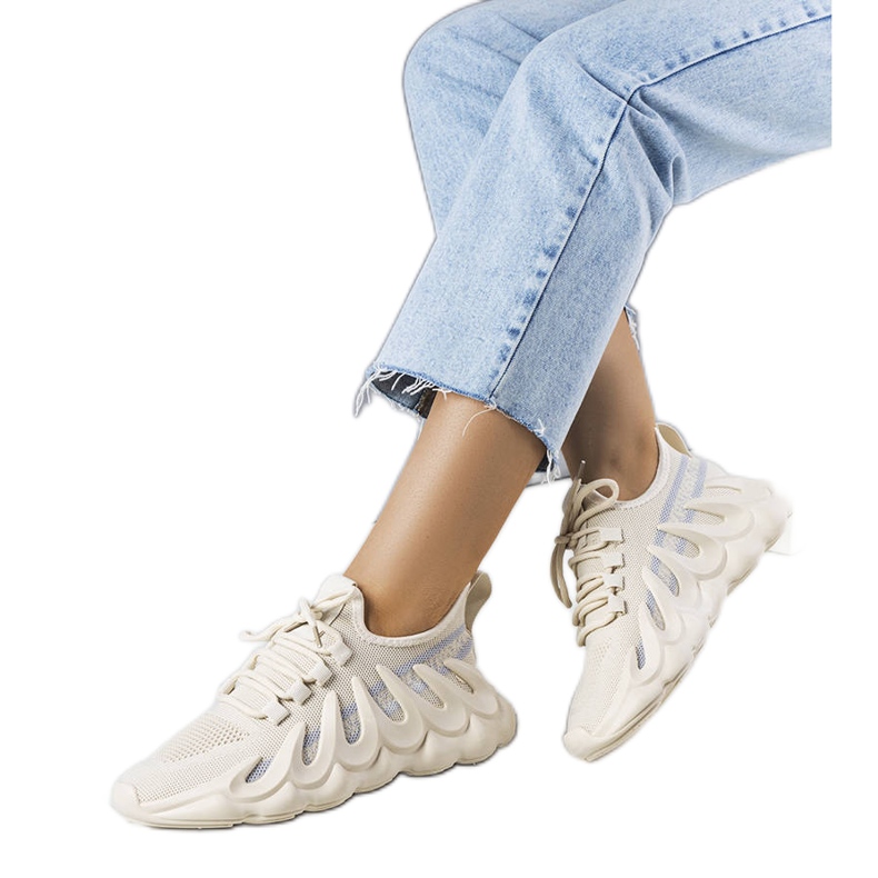 Beige sneakers på en fashionabel Beth-sula