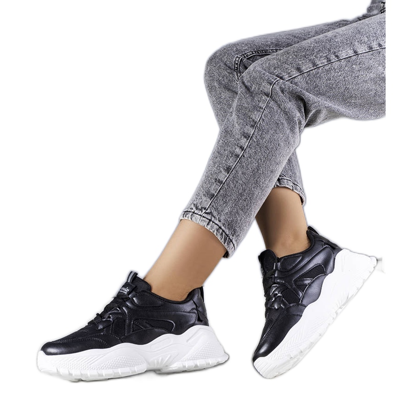 Svarta sneakers på en massiv Lorene-sula