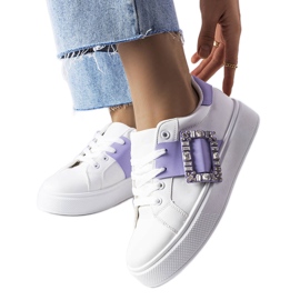 Vita sneakers dekorerade med ett lila Ike-spänne