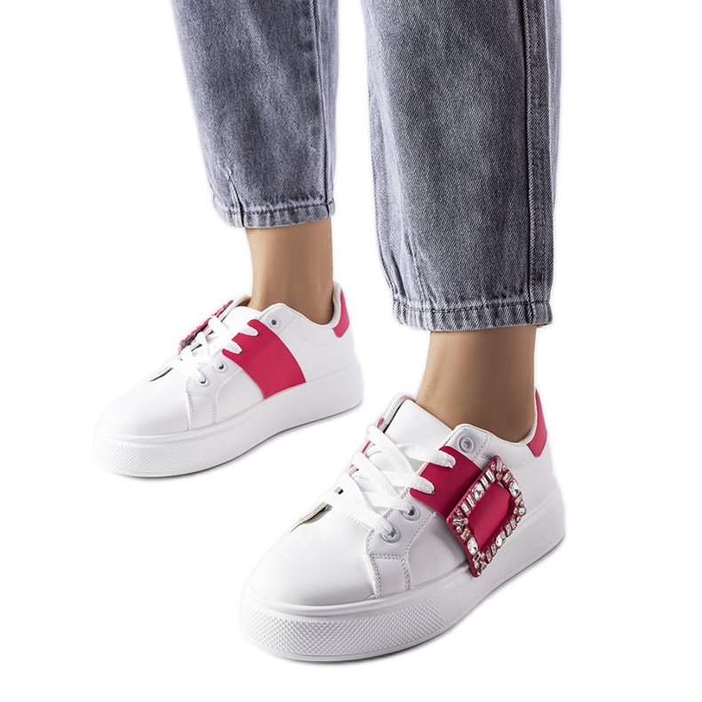 Vita sneakers dekorerade med ett rosa Ike-spänne