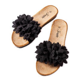 Svarta tofflor dekorerade med blommor