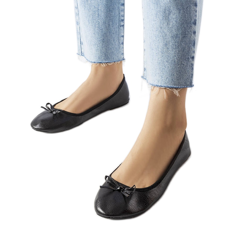 Svarta ballerinor dekorerade med en Vaillancour-rosett