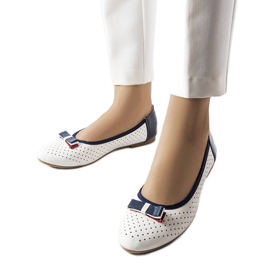 Vita genombrutna ballerinor med en Tisser-rosett