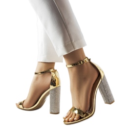 Gyllene sandaler på en dekorativ Rette-stolpe