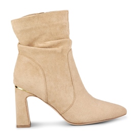 Beige damstövlar på en dekorerad stolpe