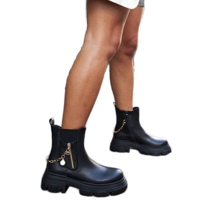 Svarta stövlar med en dekorativ Archard-kedja