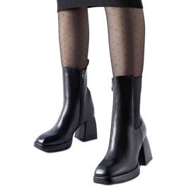 Svarta isolerade ankelboots på en massiv Adamo-klack