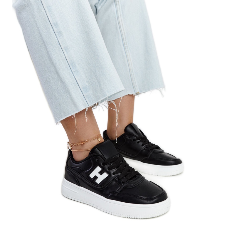 Svarta sneakers på en vit Mentha-plattform