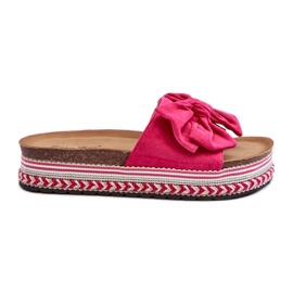Kvinnors flip-flops på en plattform med rosett Fuchsia Evatria rosa