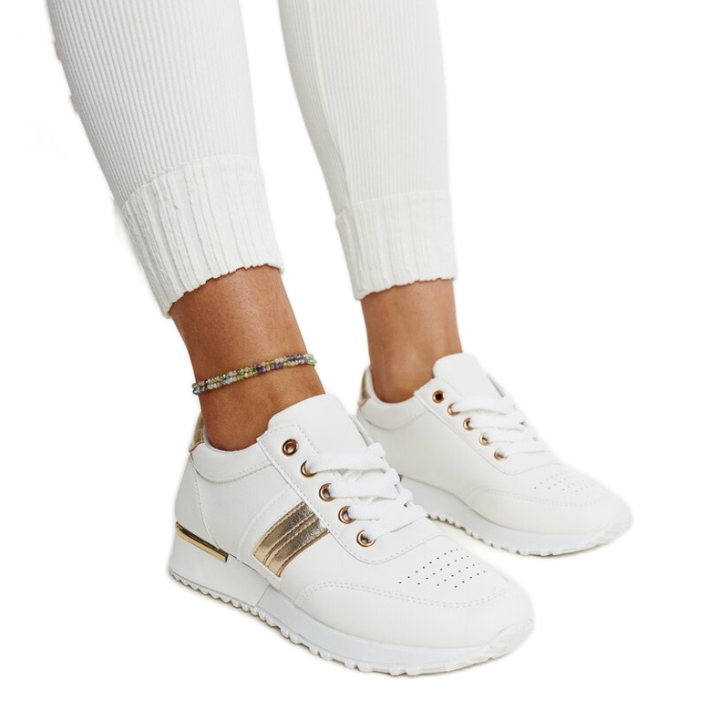 Vita och guld sneakers på Nihad gummiplattform