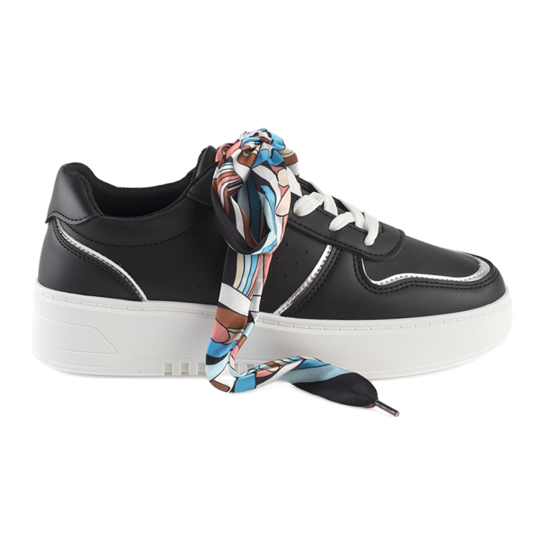 Svarta kvinnors sneakers bundna med ett band