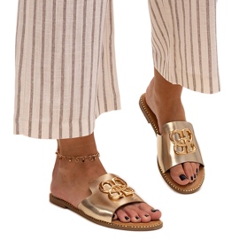 Guldflipflops dekorerade med ett Perkin-spänne gyllene