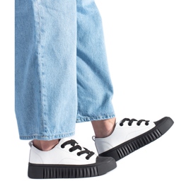 Vita och svarta low-top sneakers gjorda av naturligt läder