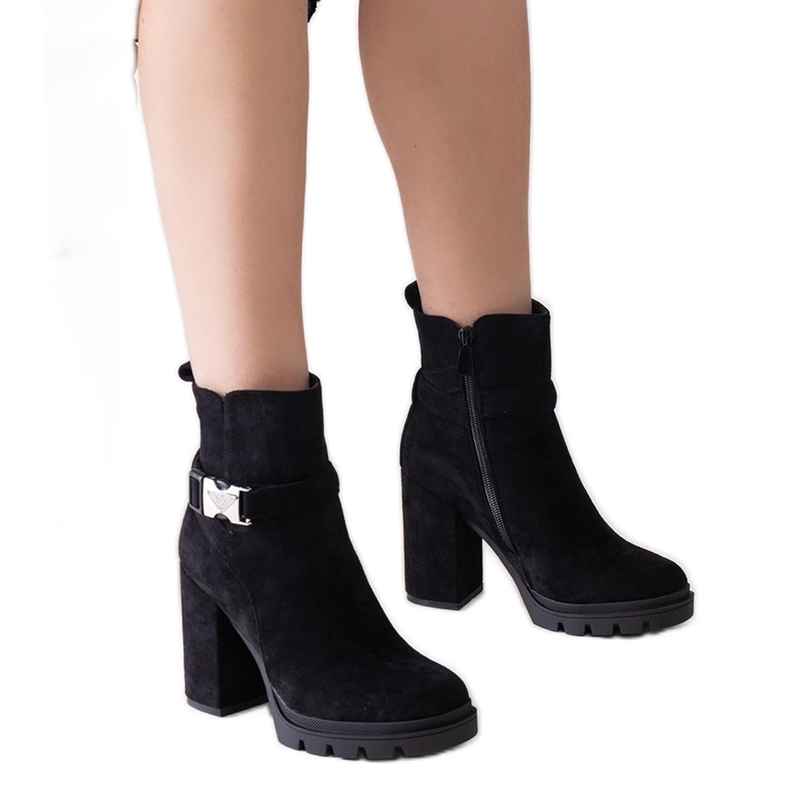 Svarta högklackade ankelboots dekorerade med ett Torhia-spänne