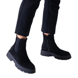 Svarta höga stövlar på en tjock Sabra plattform i ekomocka