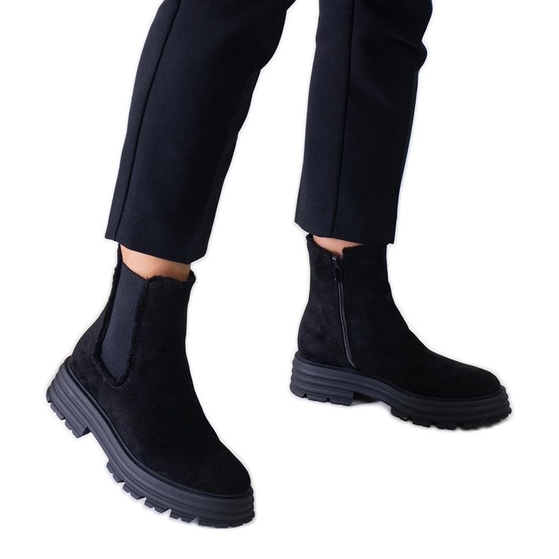 Svarta höga stövlar på en tjock Sabra plattform i ekomocka