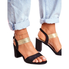 Högklackade sandaler med en dekorativ svart rem