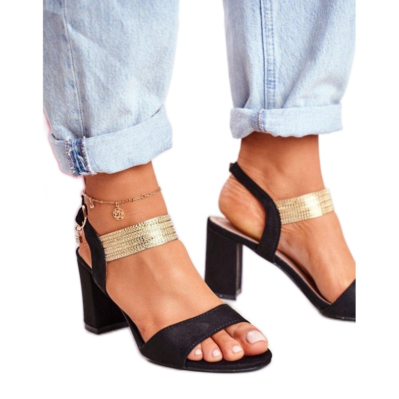 Högklackade sandaler med en dekorativ svart rem